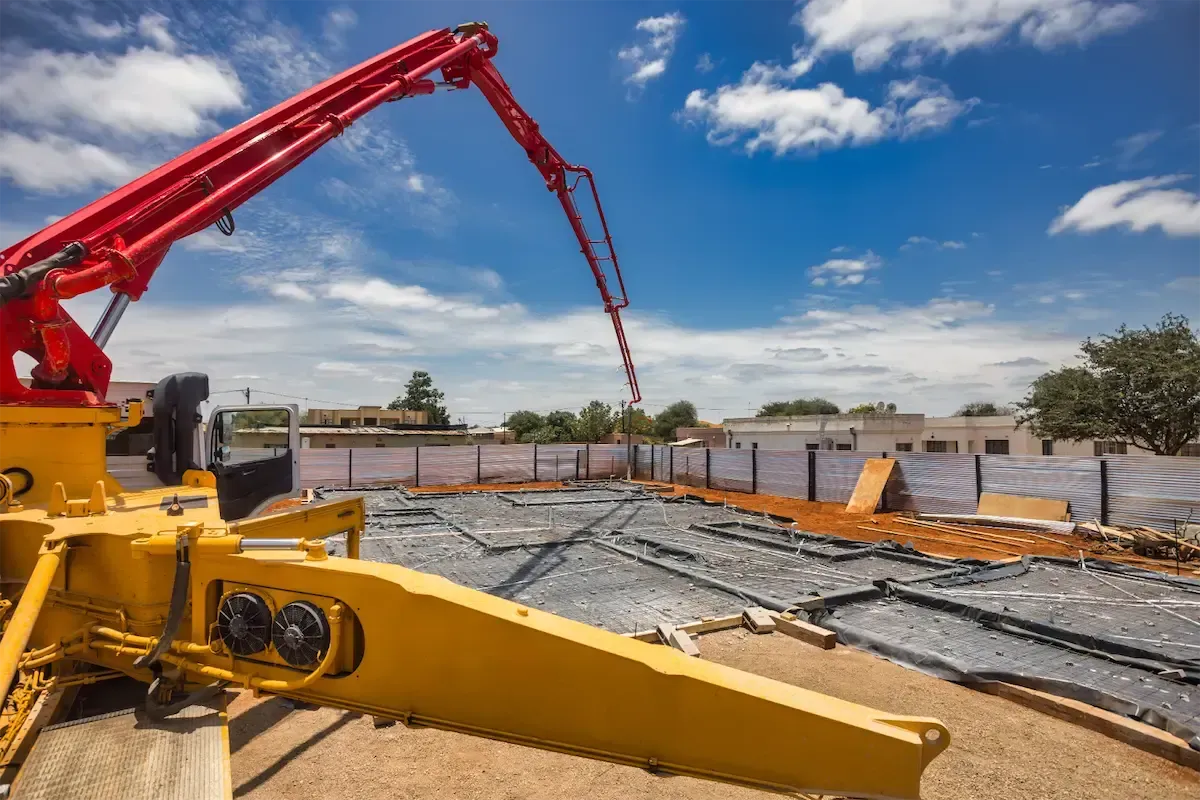 A concrete pump places Ready Mix Concrete in Addis Ababa across a large construction site with workers and equipment.