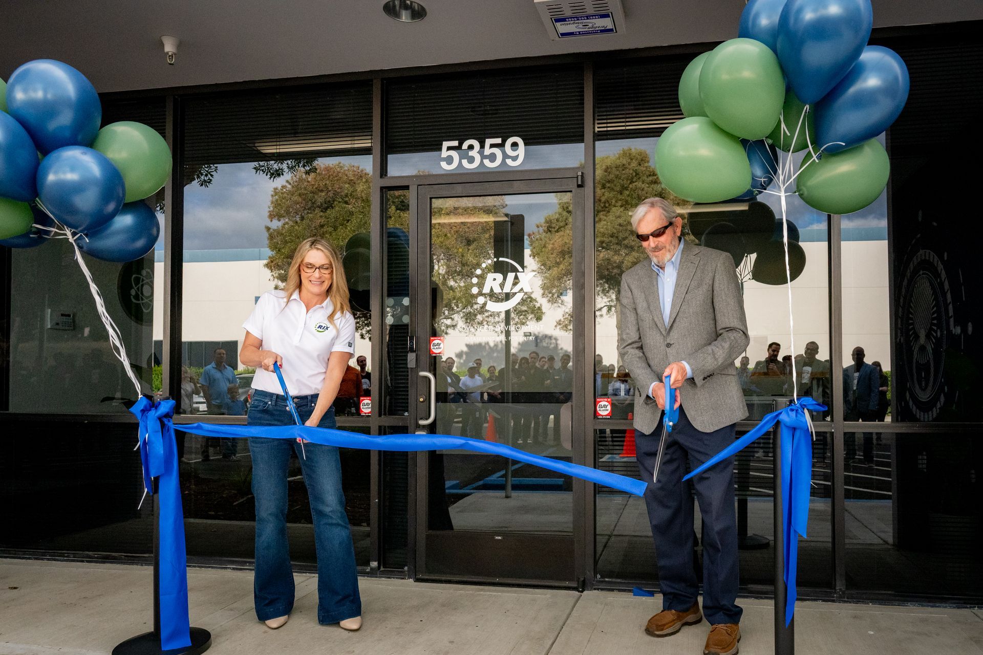 Two people cutting ribbon at a new advanced facility