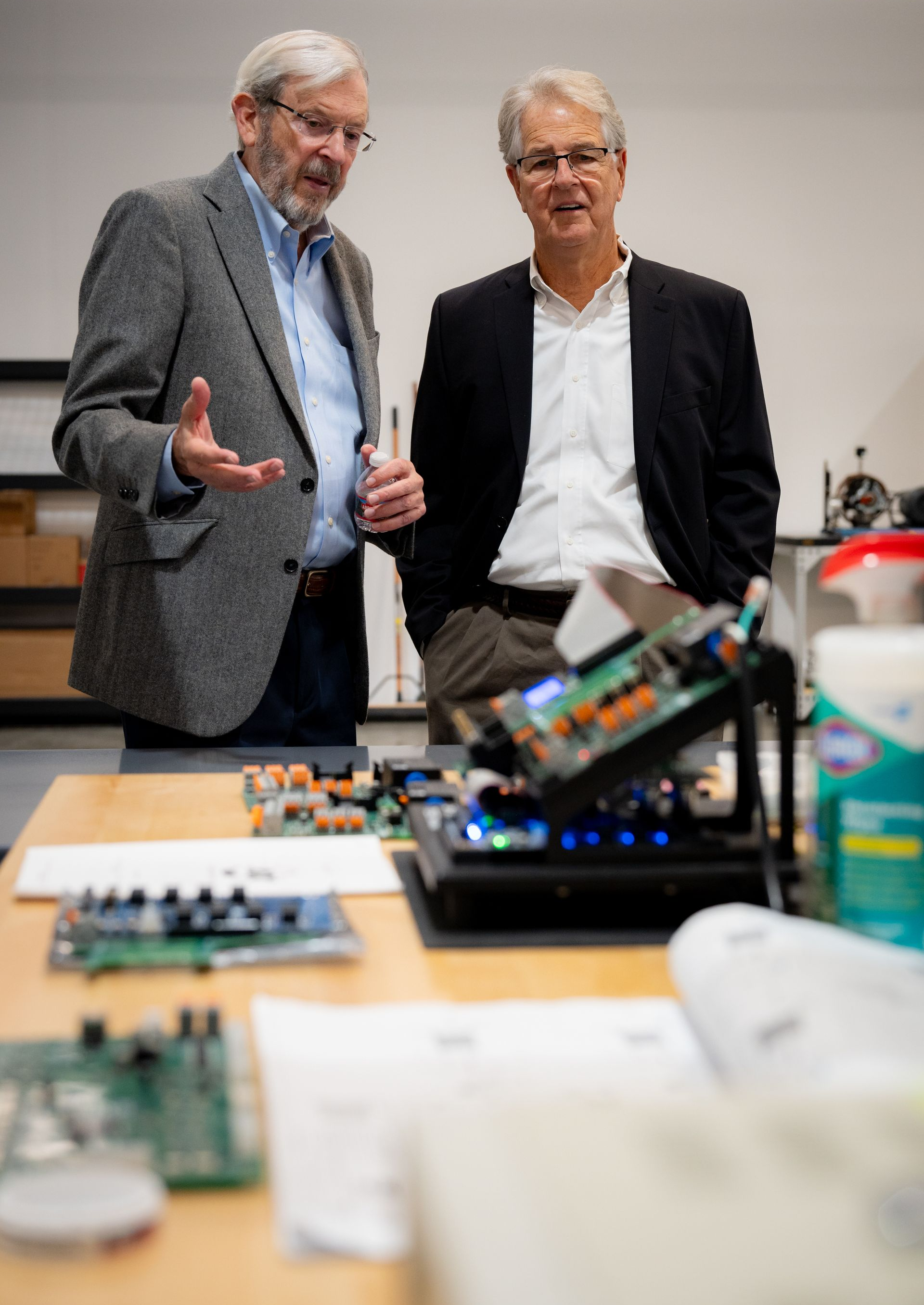 Two men discuss over technology on desk