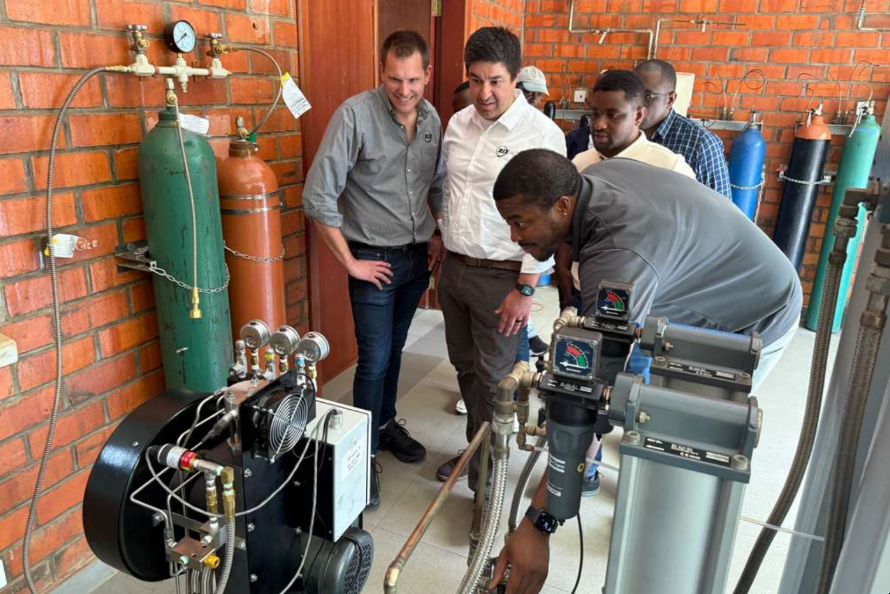 Two engineers overseeing student technicians working on an oxygen compressor