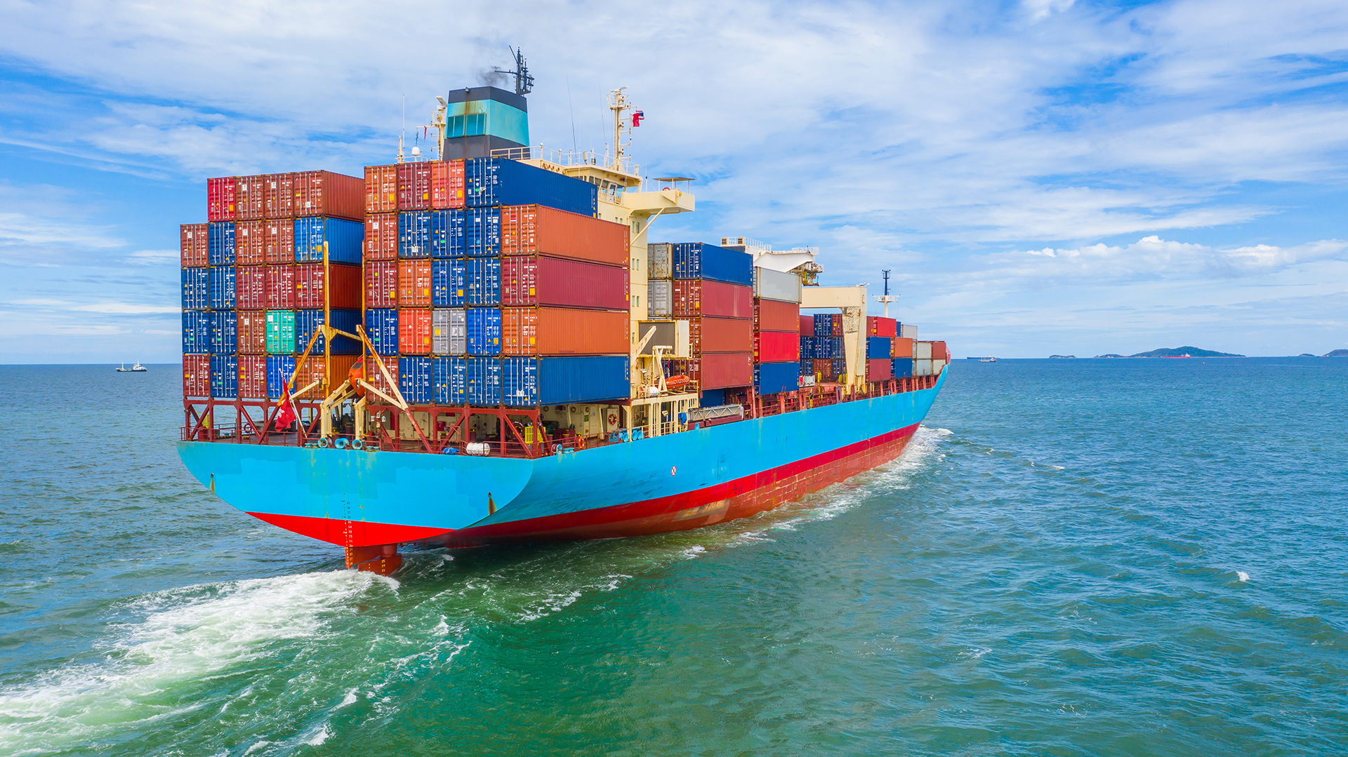 A large container ship is floating on top of a body of water.