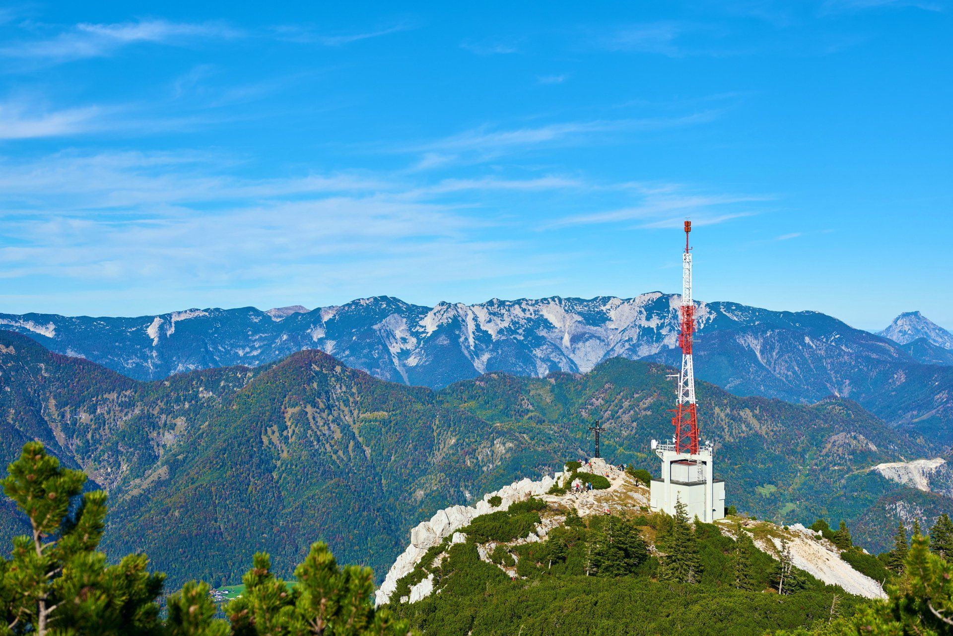 A tower on top of a mountain with mountains in the background.