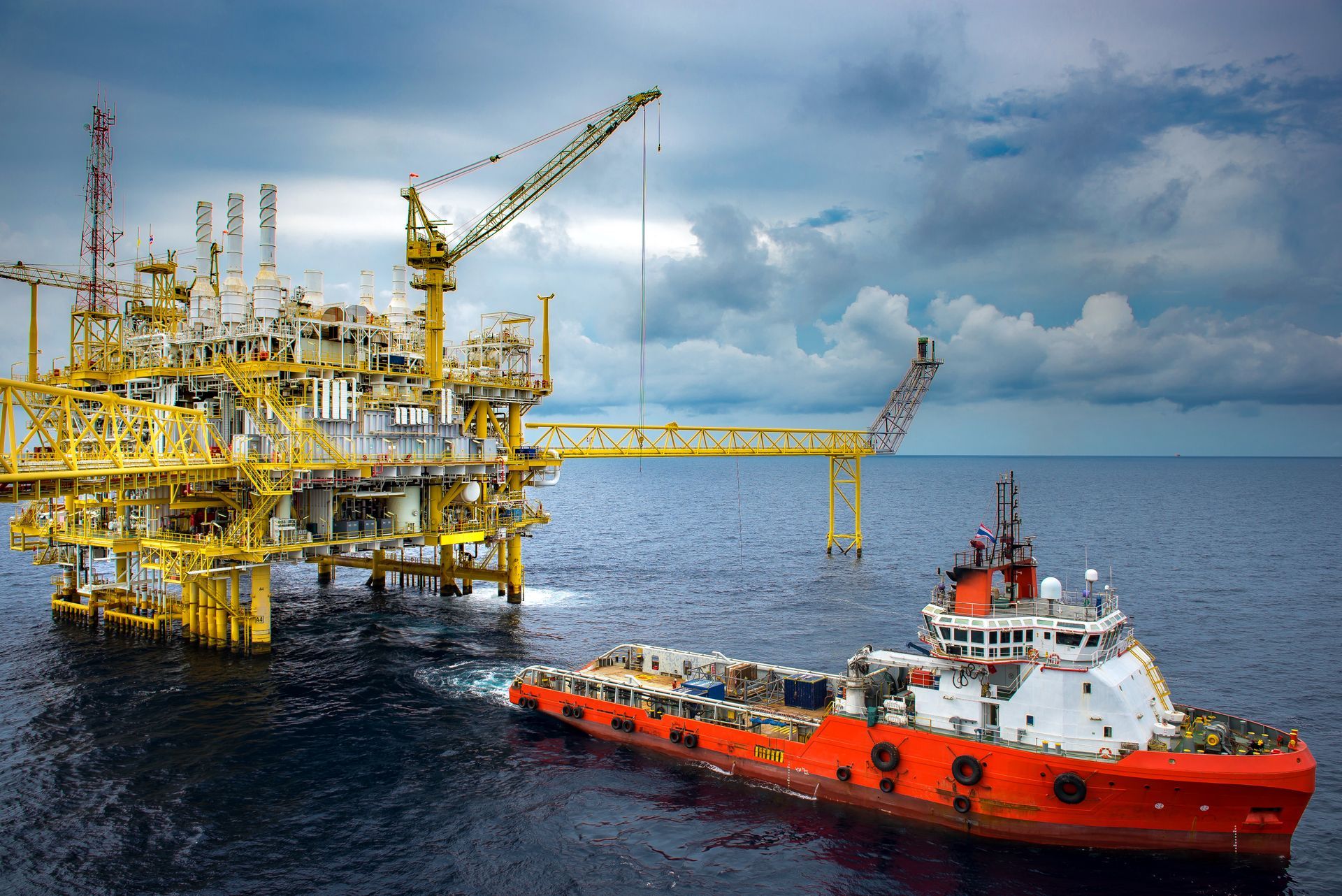 Off shore oil platform with service vessel loading/unloading