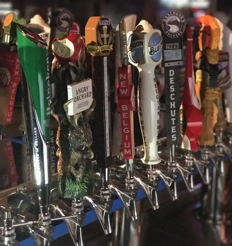 A row of beer taps including new belgium and deschutes