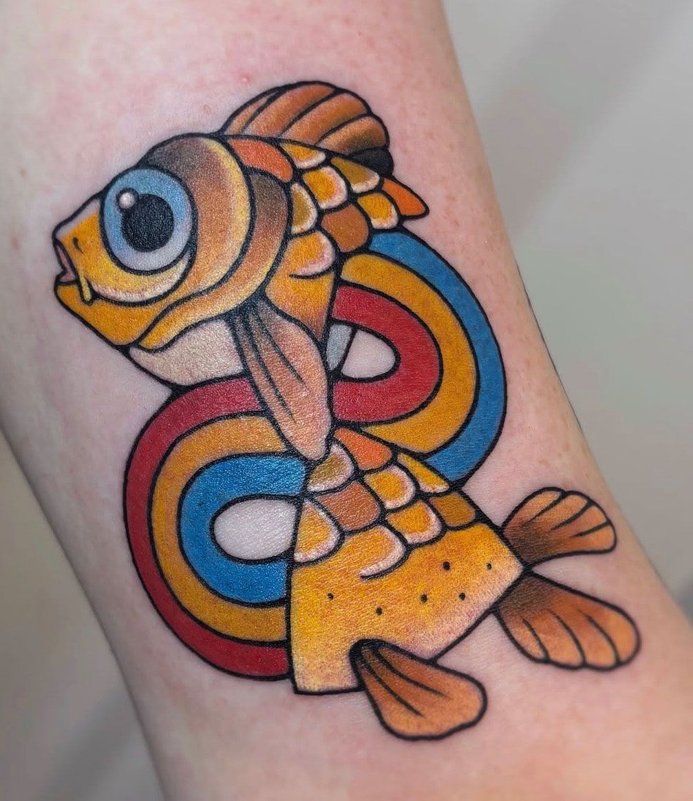 Colorful illustrative fish tattoo by Jacy Andrew, featuring a big-eyed orange fish surrounded by looping red, yellow, and blue ribbons.