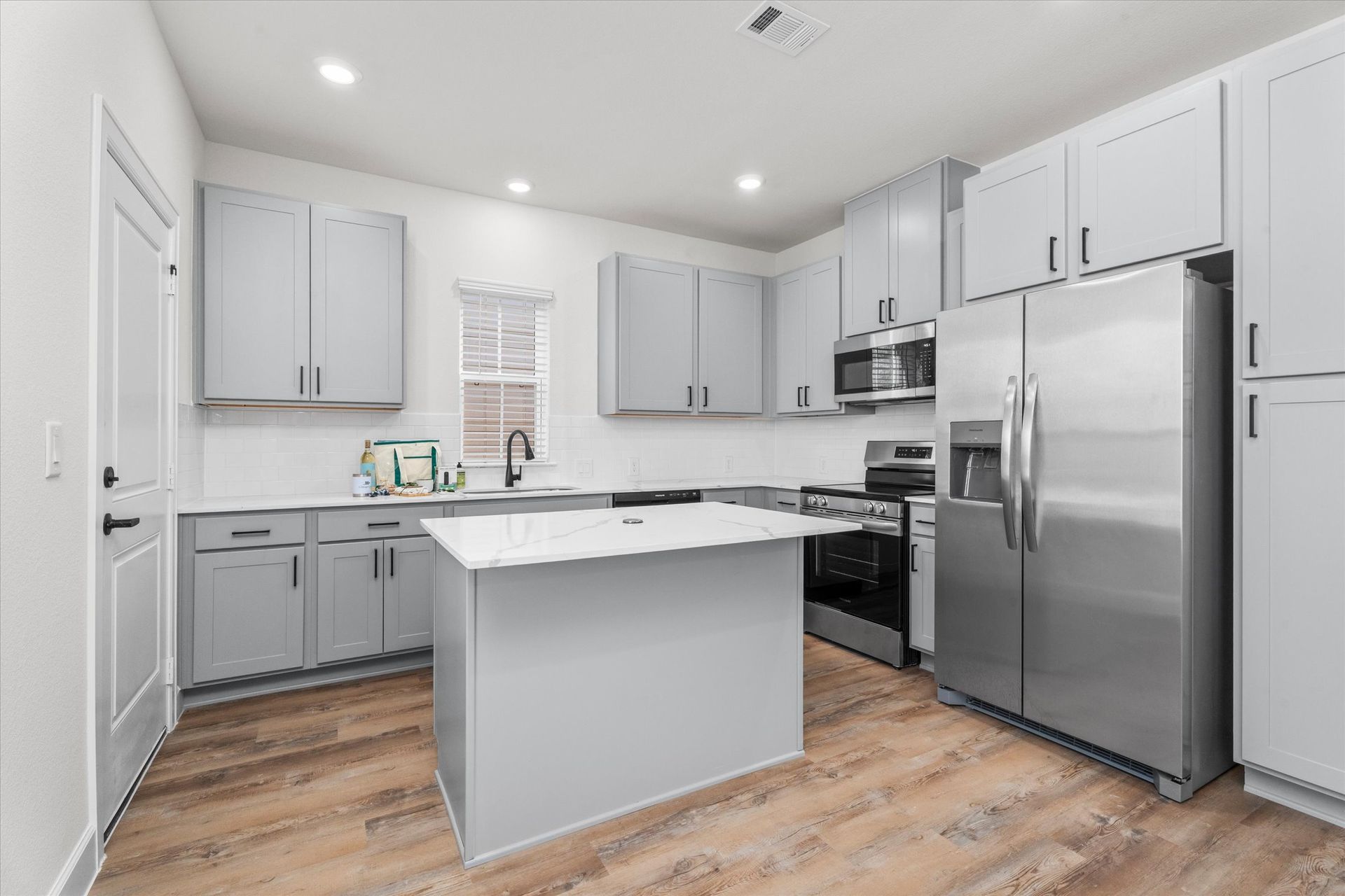 Modern apartment kitchen with stainless steel appliances at The Cottage Green Baytown apartments