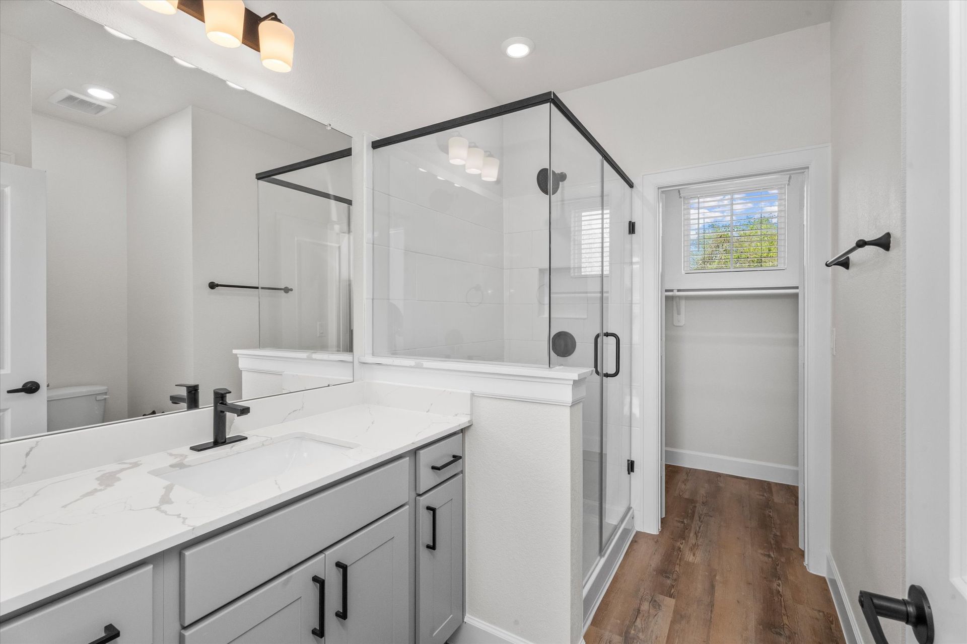 Modern apartment bathroom with walk-in shower at The Cottage Green Baytown in Baytown TX