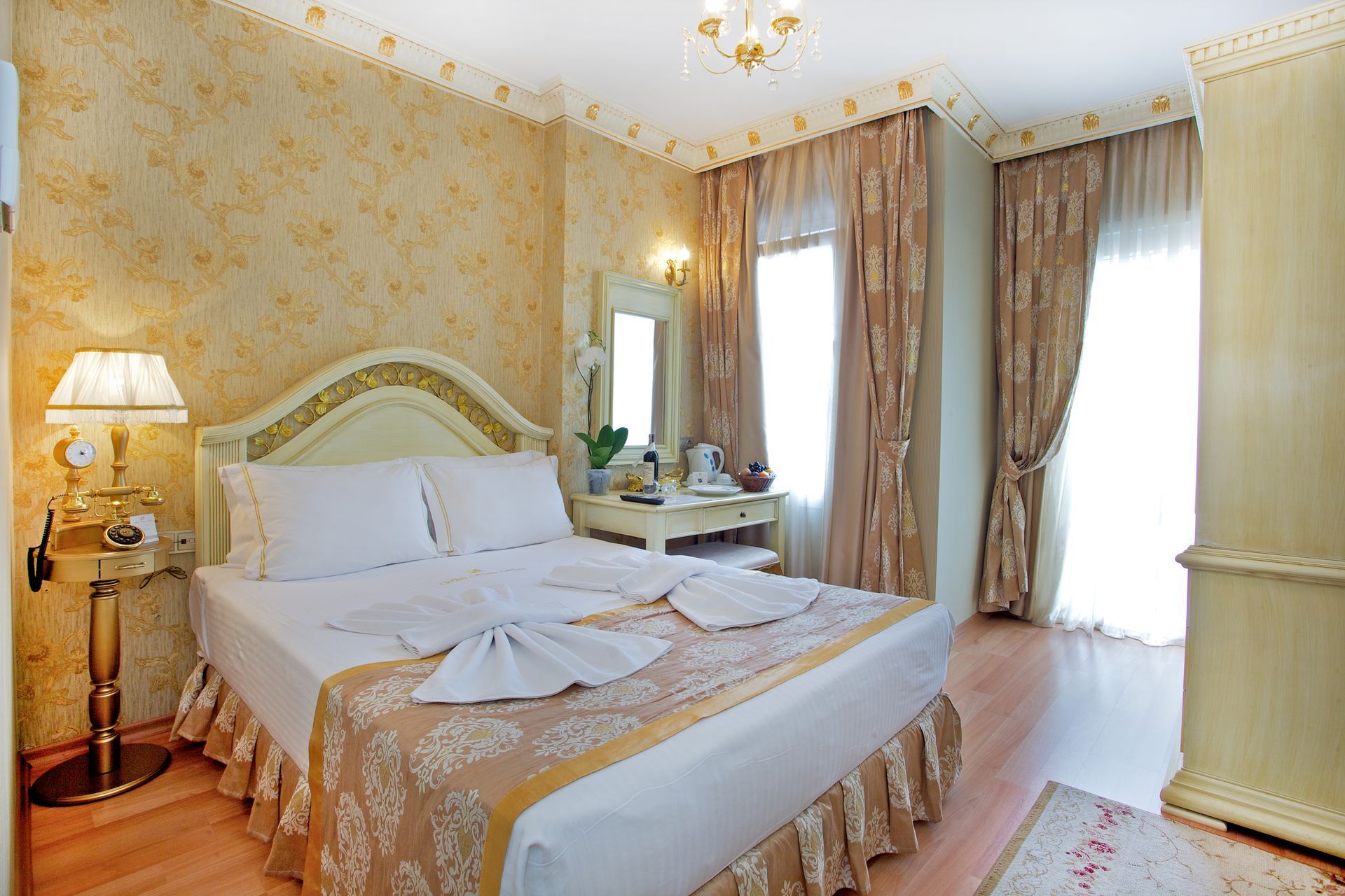 Istanbul white house hotel | Elegant bedroom with a king bed, cream wallpaper, chandelier