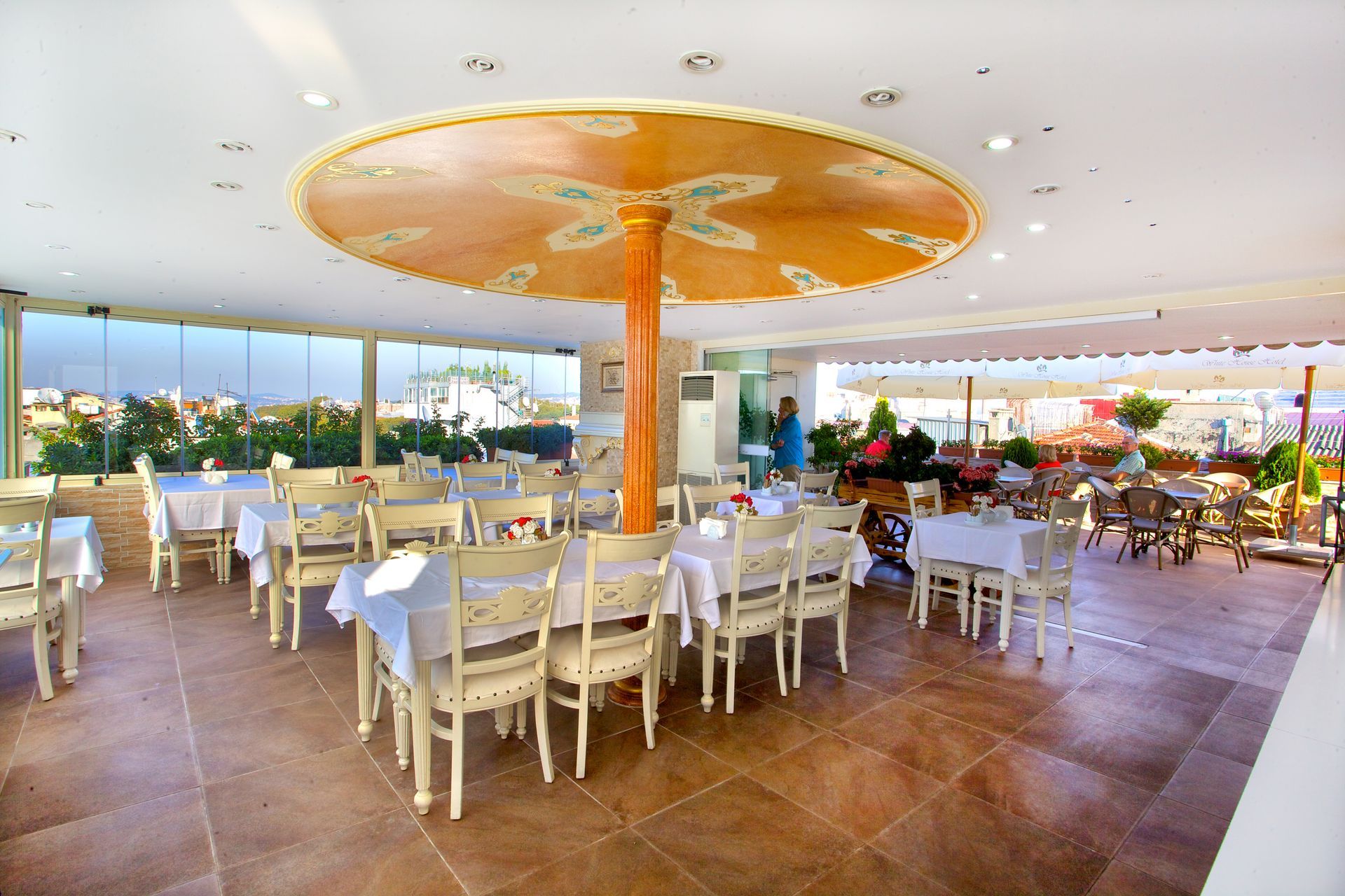 Istanbul white house hotel | Open-air restaurant with white chairs, wooden tables,