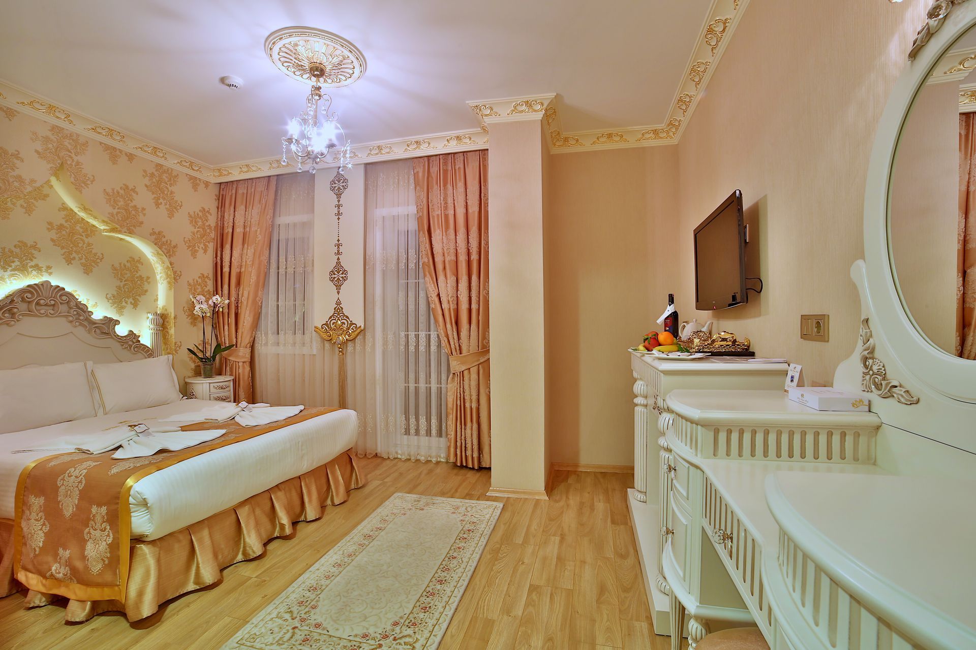 Istanbul white house hotel | Elegant pink bedroom with ornate bed, chandelier, vanity, and sheer curtains