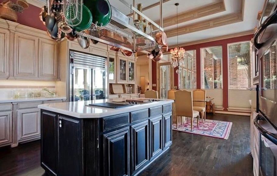 Spacious kitchen with a large dark island, wood cabinets, and a bright windowed dining nook.