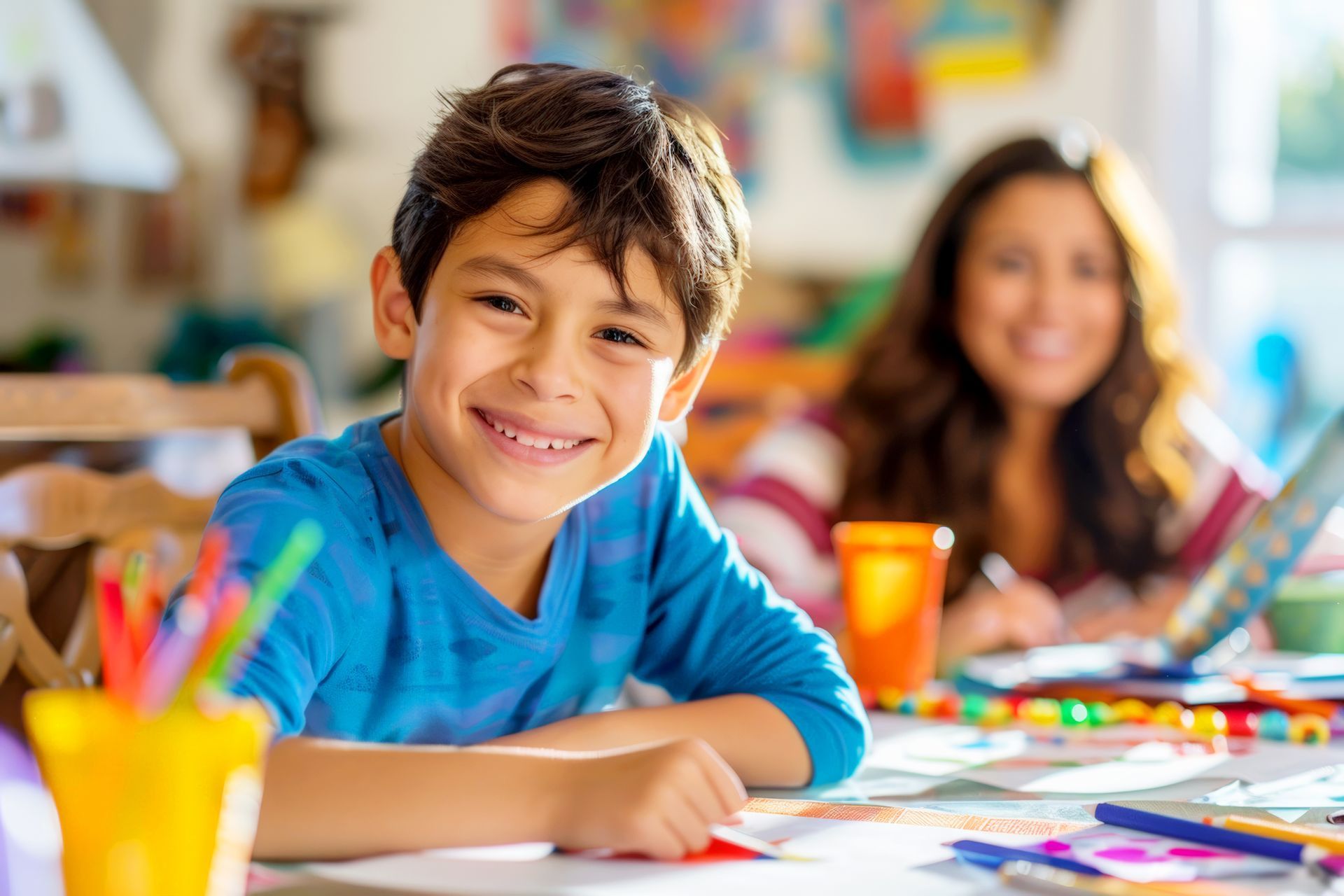 Smiling boy drawing with pencils during homework club activity in a bright classroom. Smiling boy drawing with pencils during homework club activity in a bright classroom.