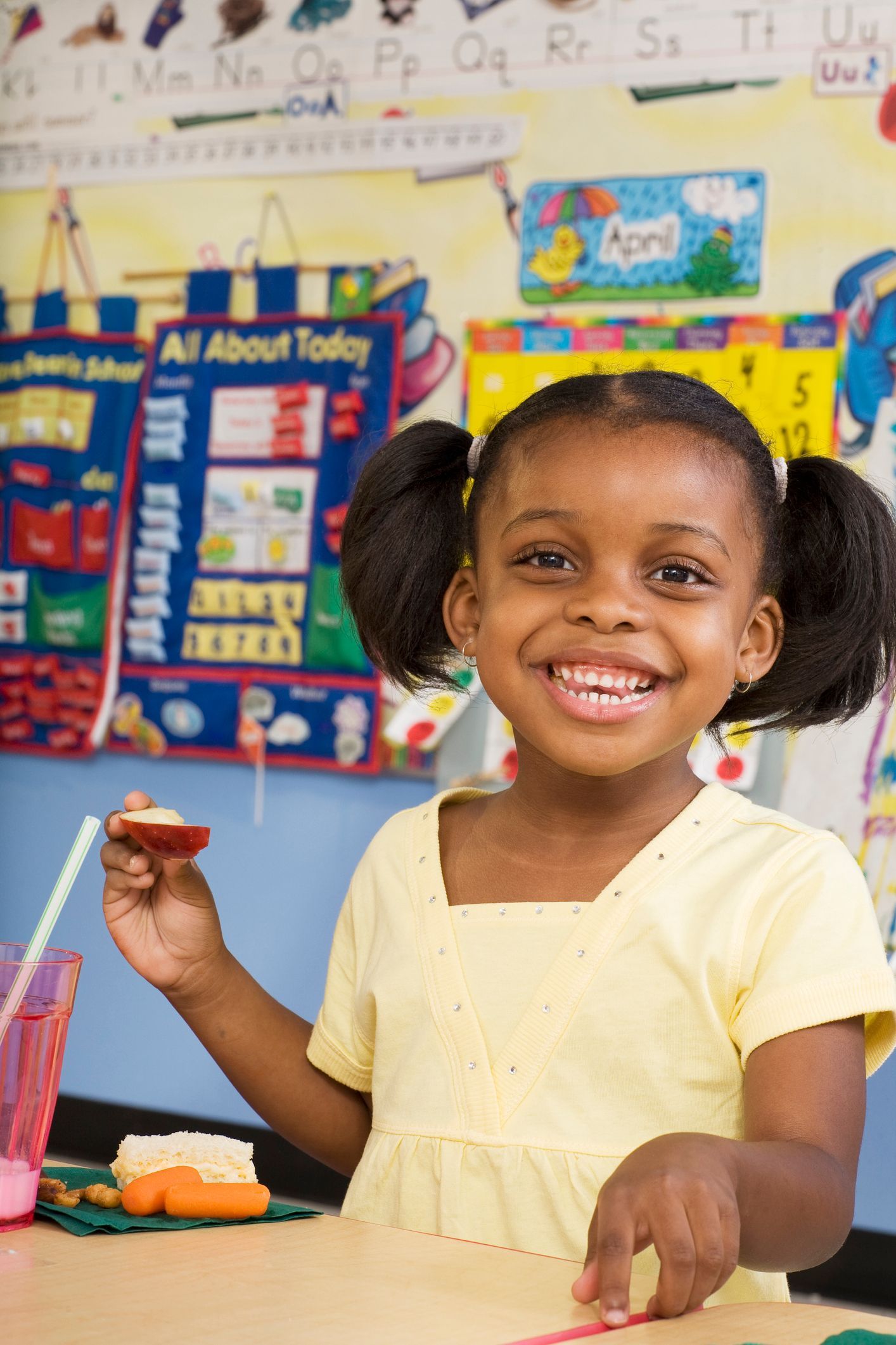 Small 4-year-old girl smiling at the camera in Pre-K