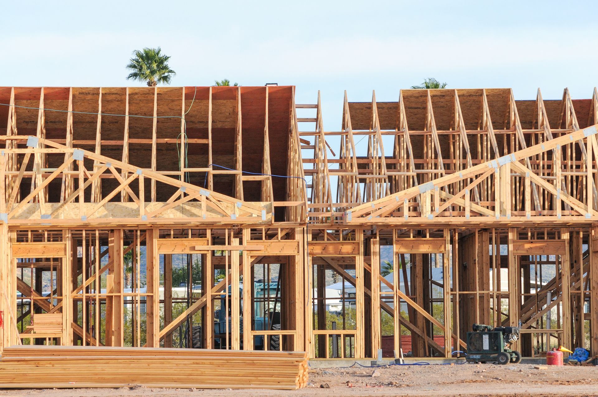 Wooden house frame under construction with exposed beams and trusses.