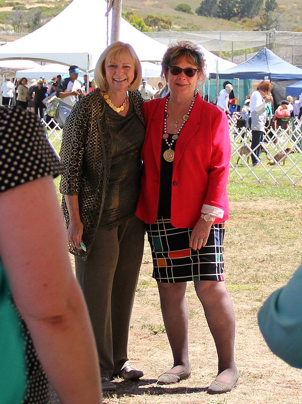 Two women standing next to each other in a field
