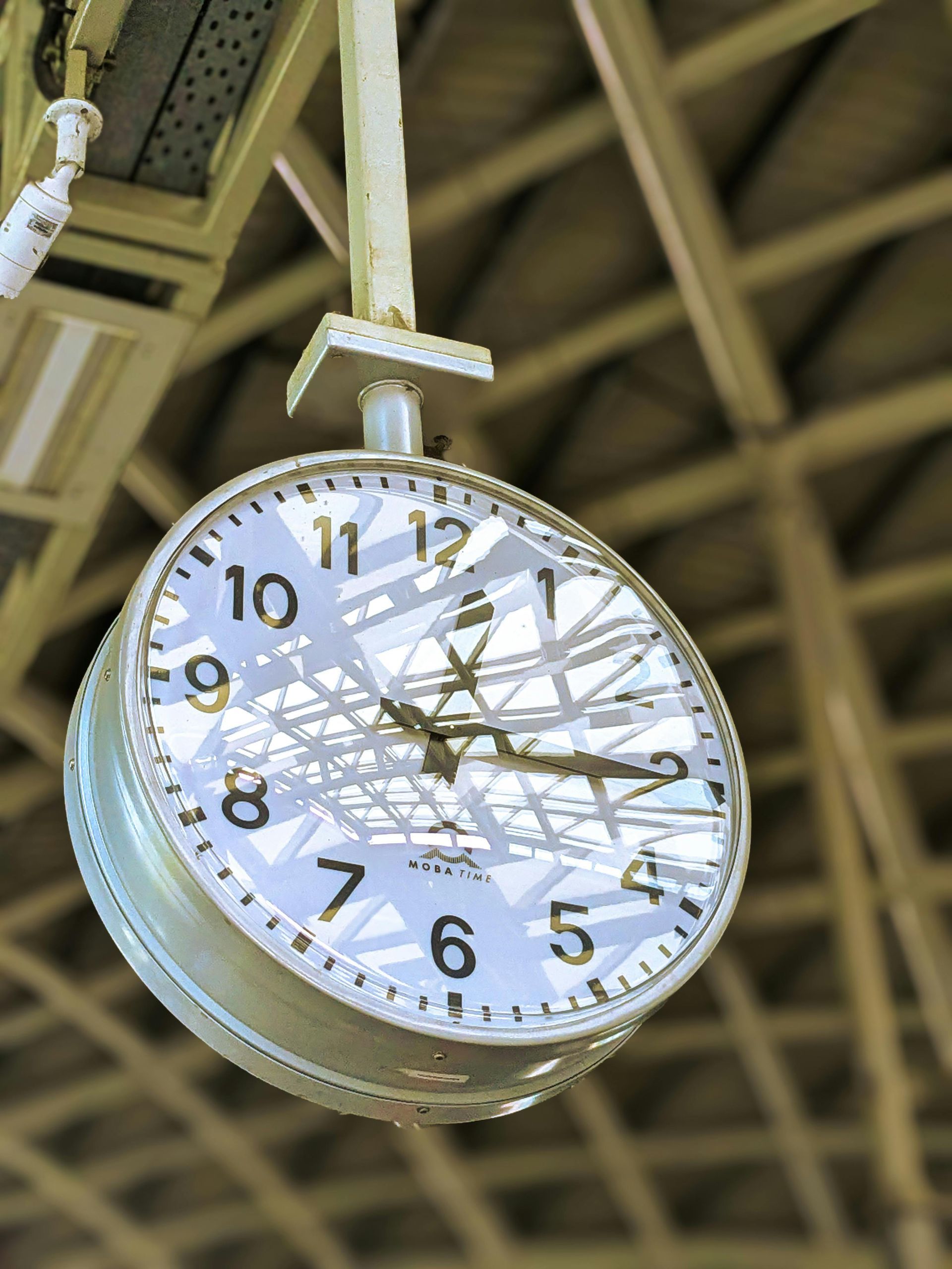 A clock is hanging from the ceiling and shows the time as 4:20