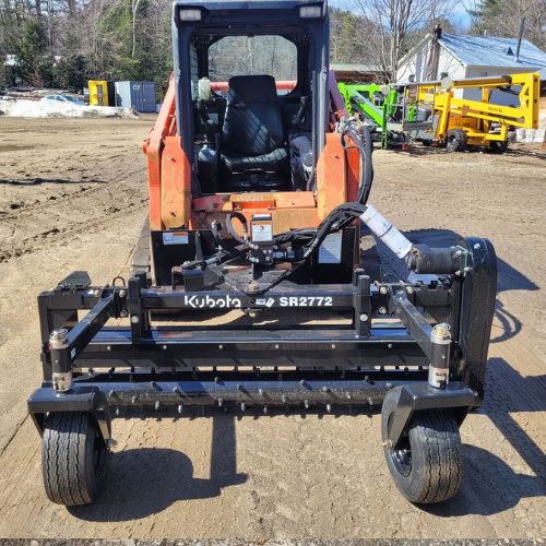 A kubota tractor is parked in a dirt lot