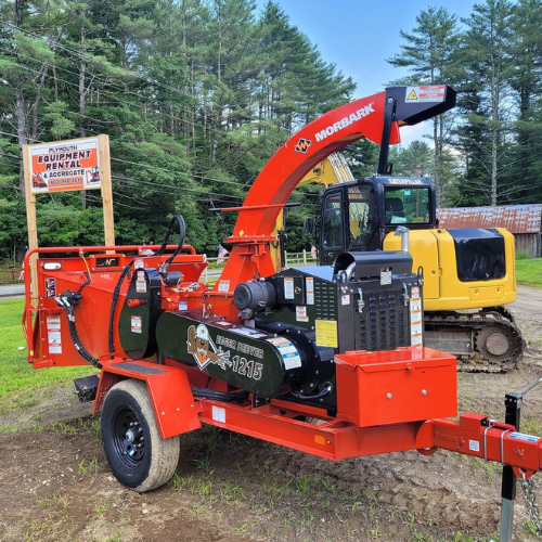 A wood chipper is parked on a trailer next to a yellow excavator.