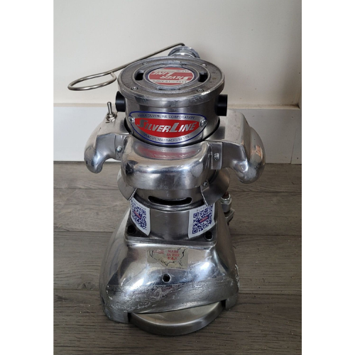 A silver vacuum cleaner is sitting on a wooden floor.