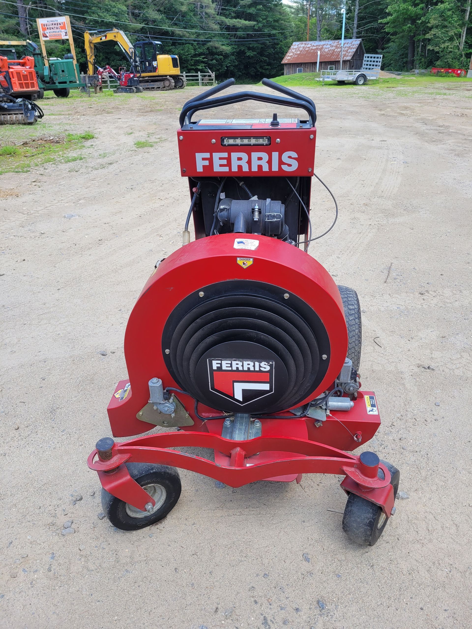 A gas powered pressure washer is sitting in the grass