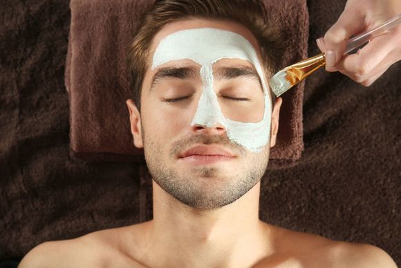 a man is getting a face mask at a spa