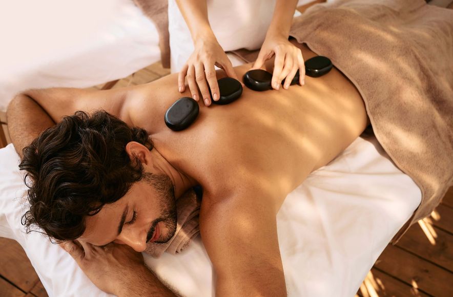 a man is getting a hot stone massage at a spa