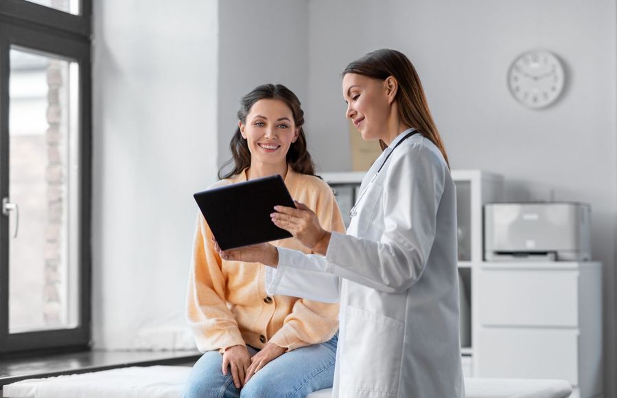 a doctor is talking to a patient while holding a tablet