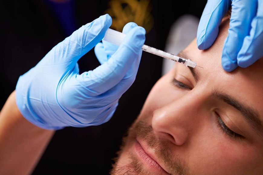 a man is getting a botox injection in his forehead