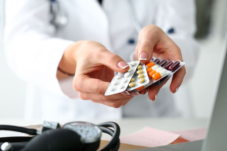 a doctor is holding a blister pack of pills in her hands