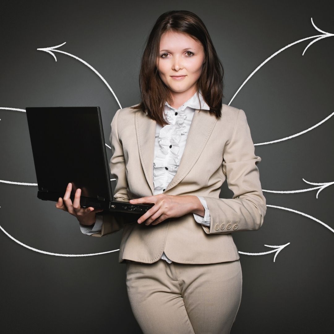 A imagem mostras uma mulher segurando um notebook com setas direcionais ao redor