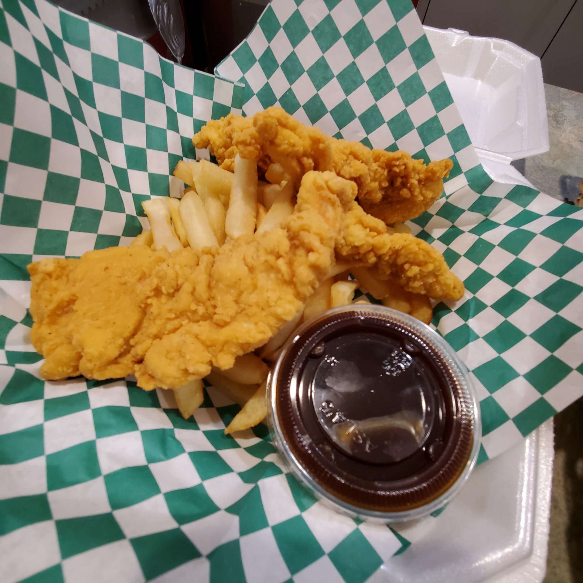 a plate of fried chicken and french fries with a dipping sauce