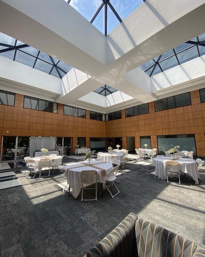 A large room with tables and chairs and a skylight