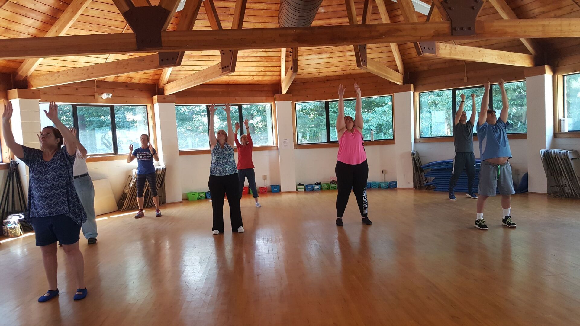 A group of people are standing in a room with their arms in the air.