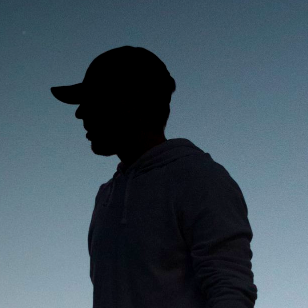 A silhouette of a man wearing a baseball cap
