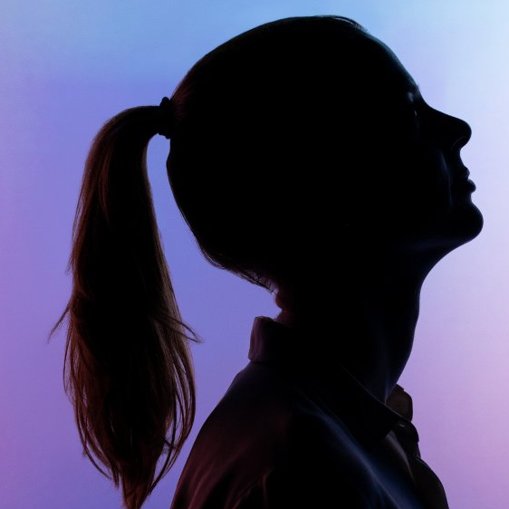 A silhouette of a woman with her hair in a ponytail