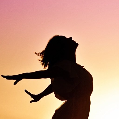 A silhouette of a woman with her arms outstretched