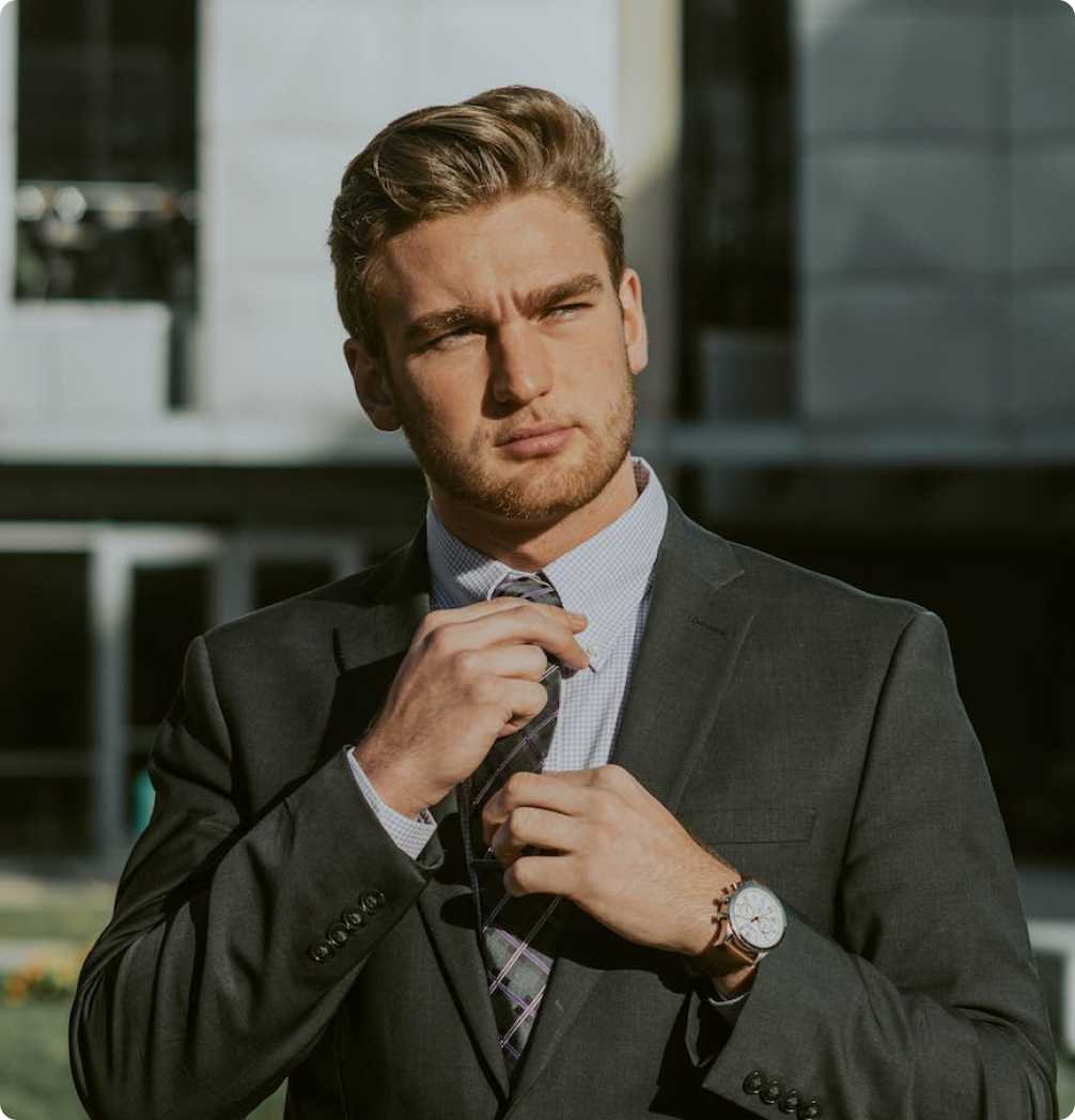 A man in a suit and tie is adjusting his tie