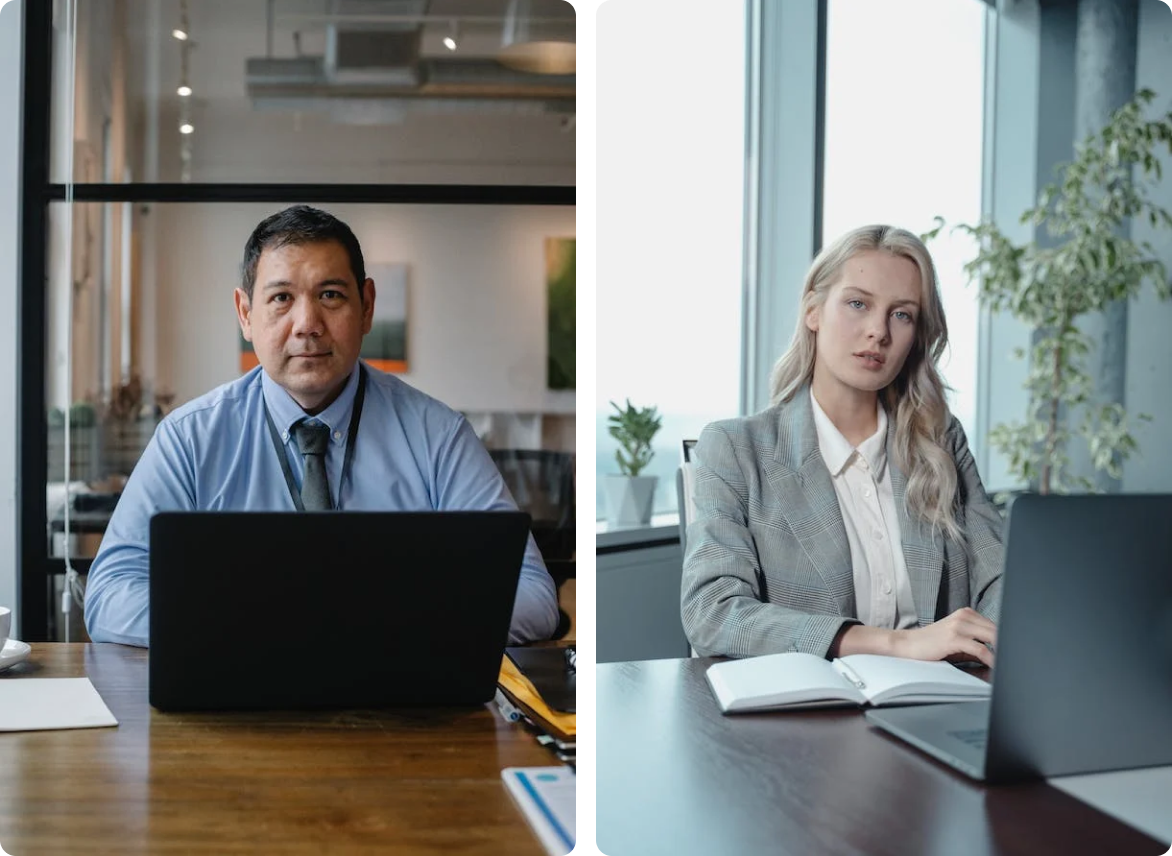 A man and a woman are sitting at a desk with laptops.