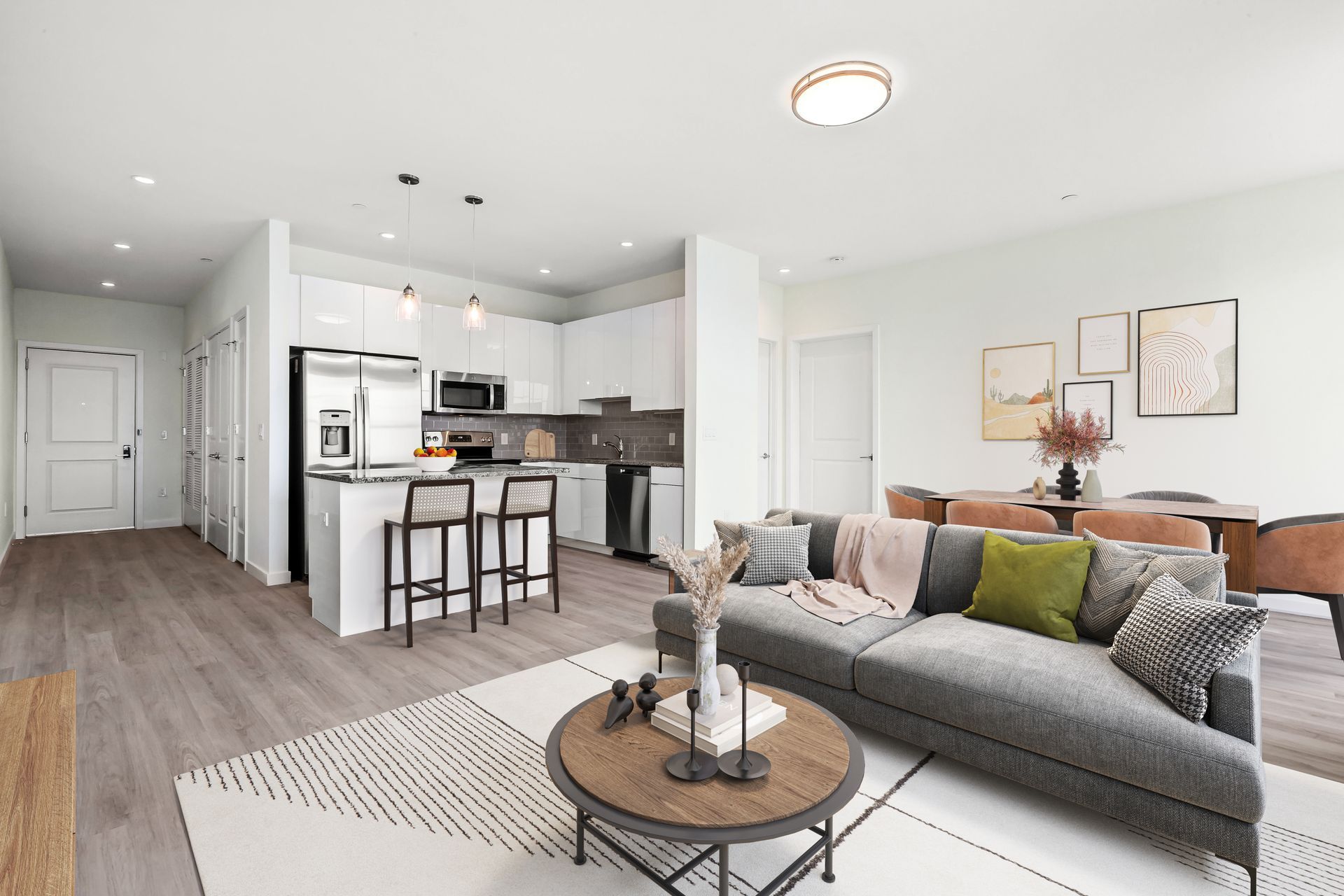 a living room with a couch , table , chairs and a kitchen .