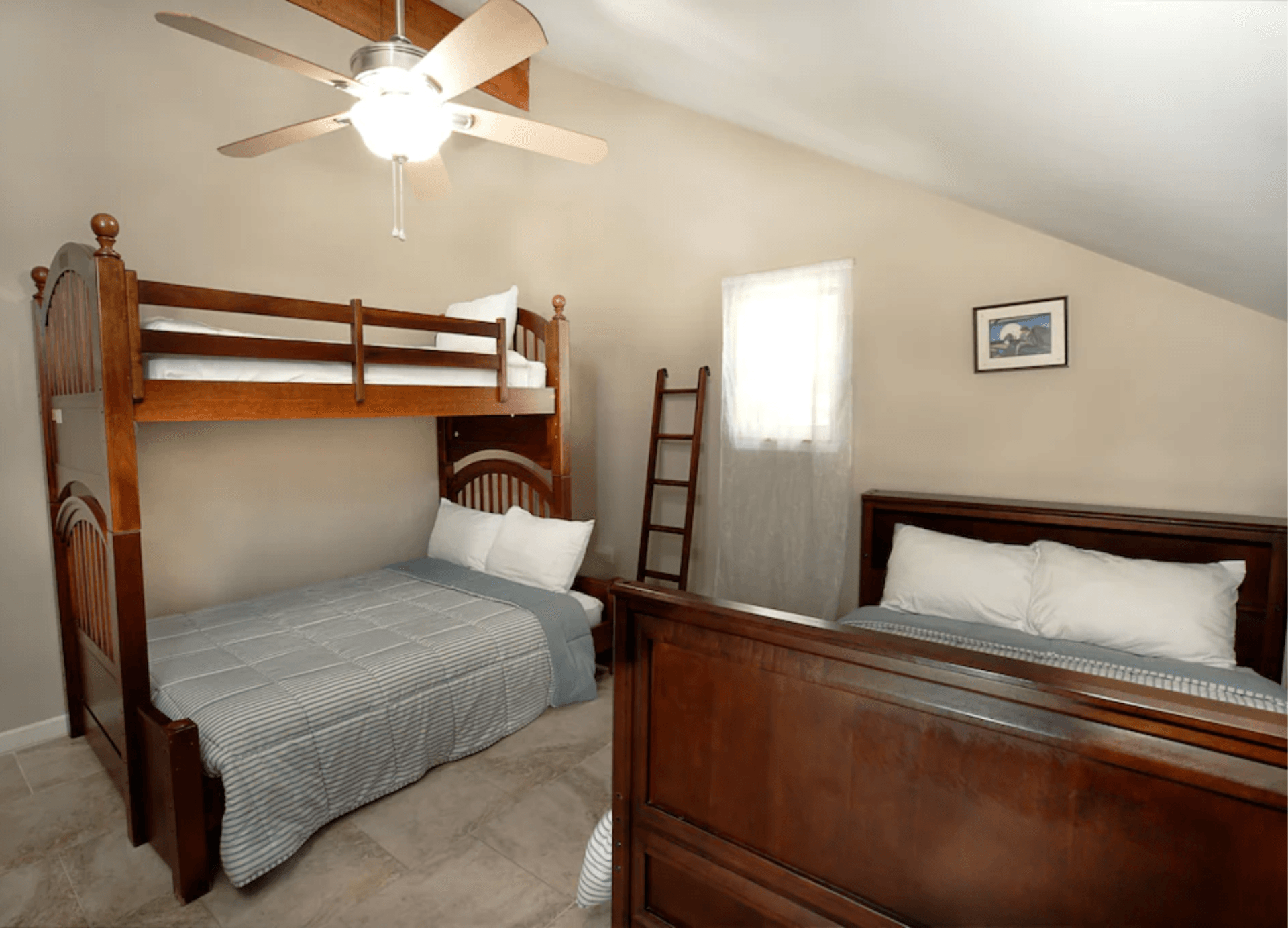 A bedroom with two bunk beds and a ceiling fan.