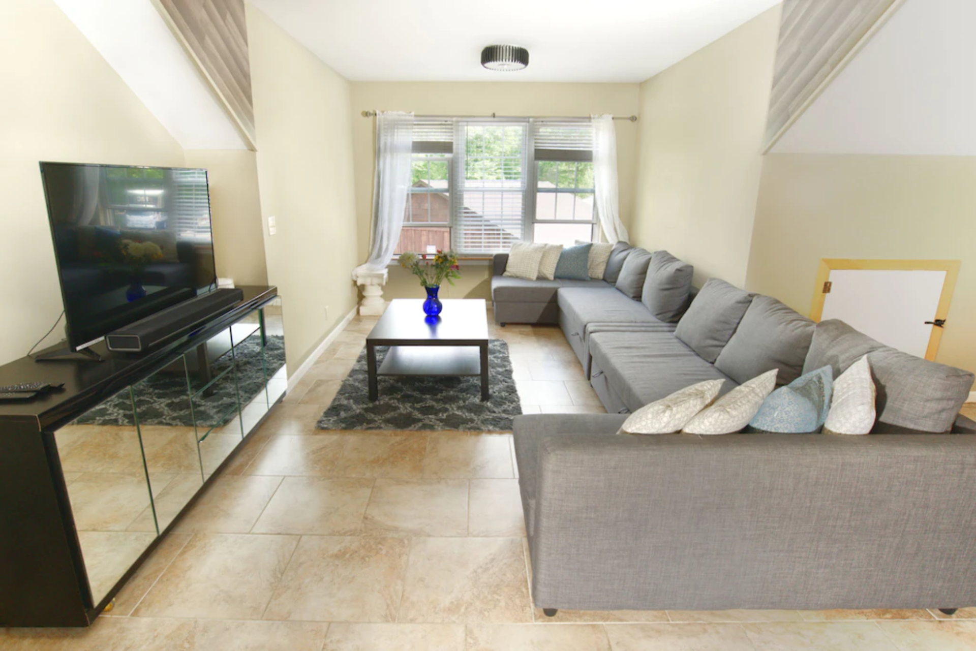 A living room with a large sectional couch and a flat screen tv