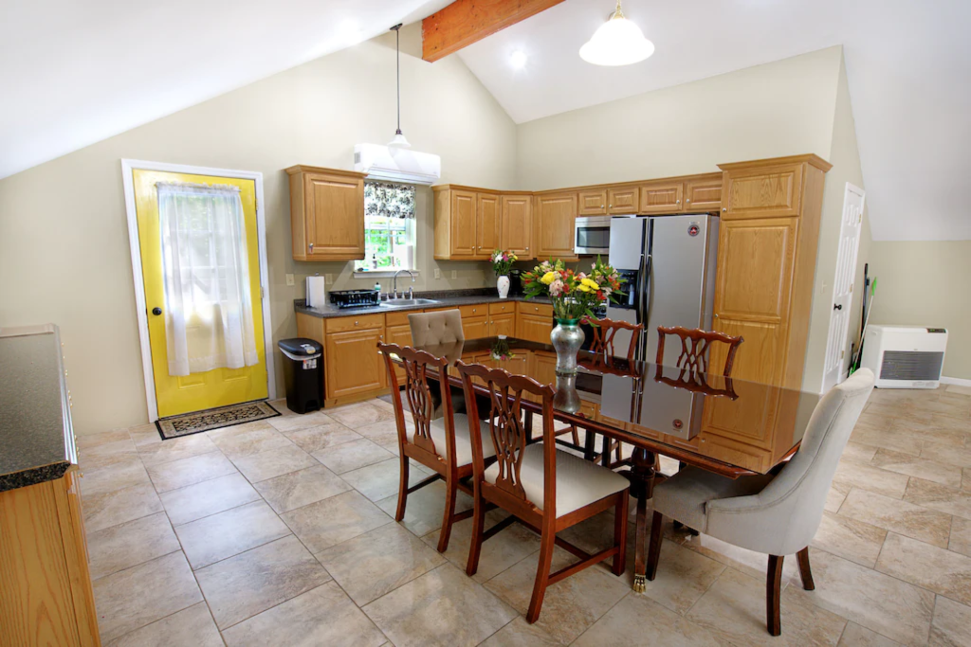 A kitchen with a table and chairs and a yellow door