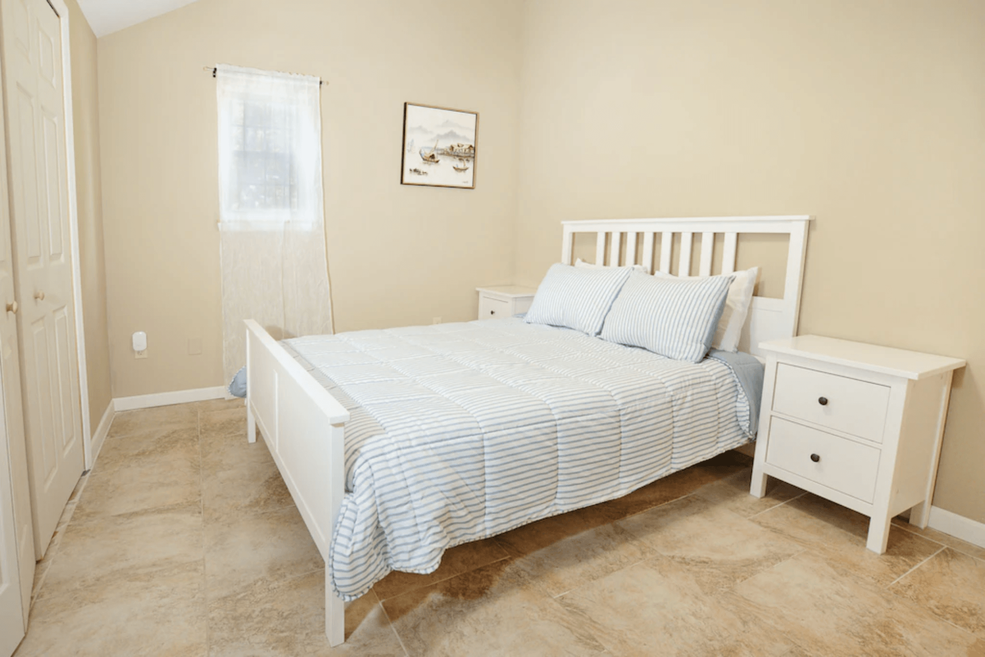 A bedroom with a bed , nightstand , and window.