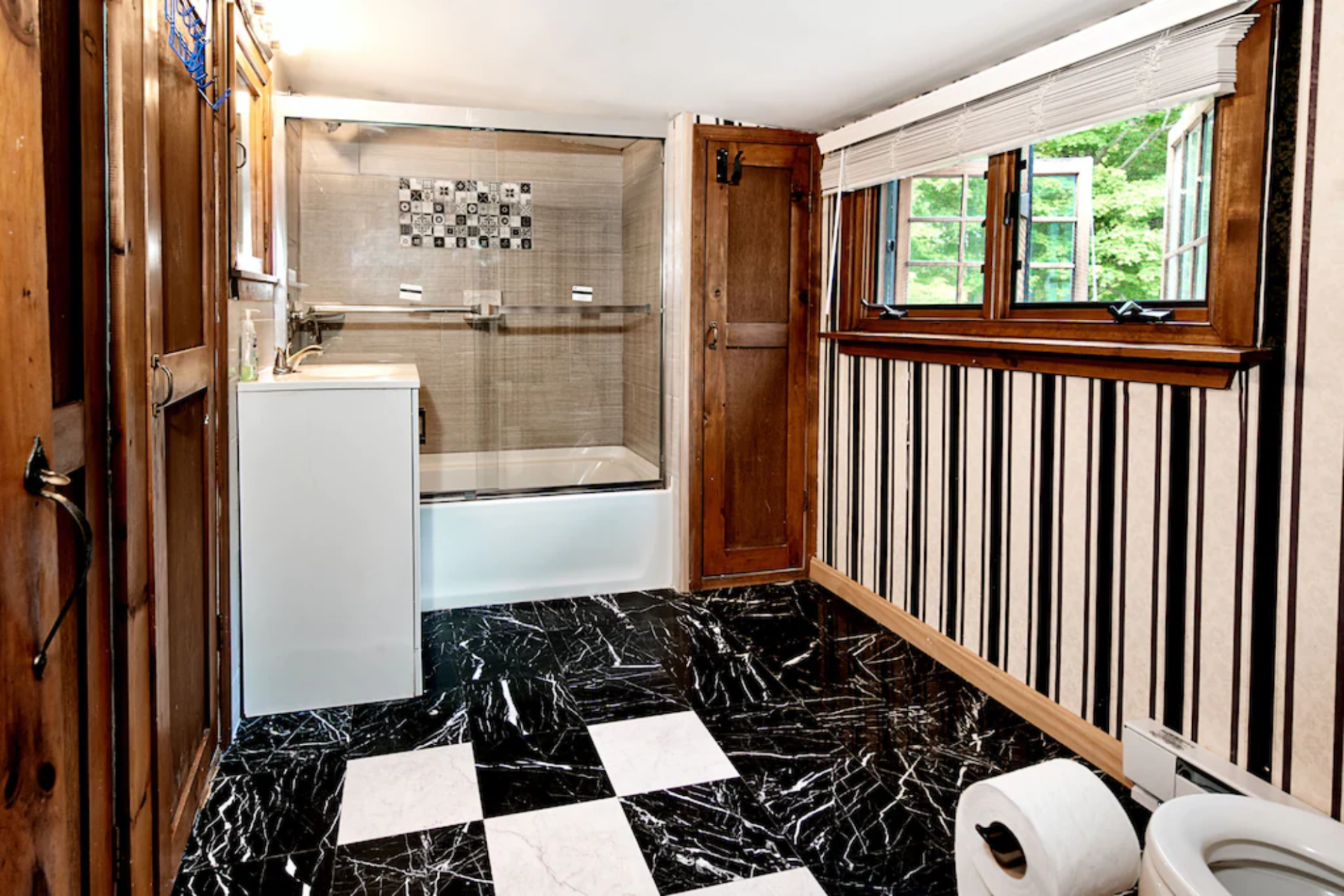 A bathroom with a black and white checkered floor and a toilet.