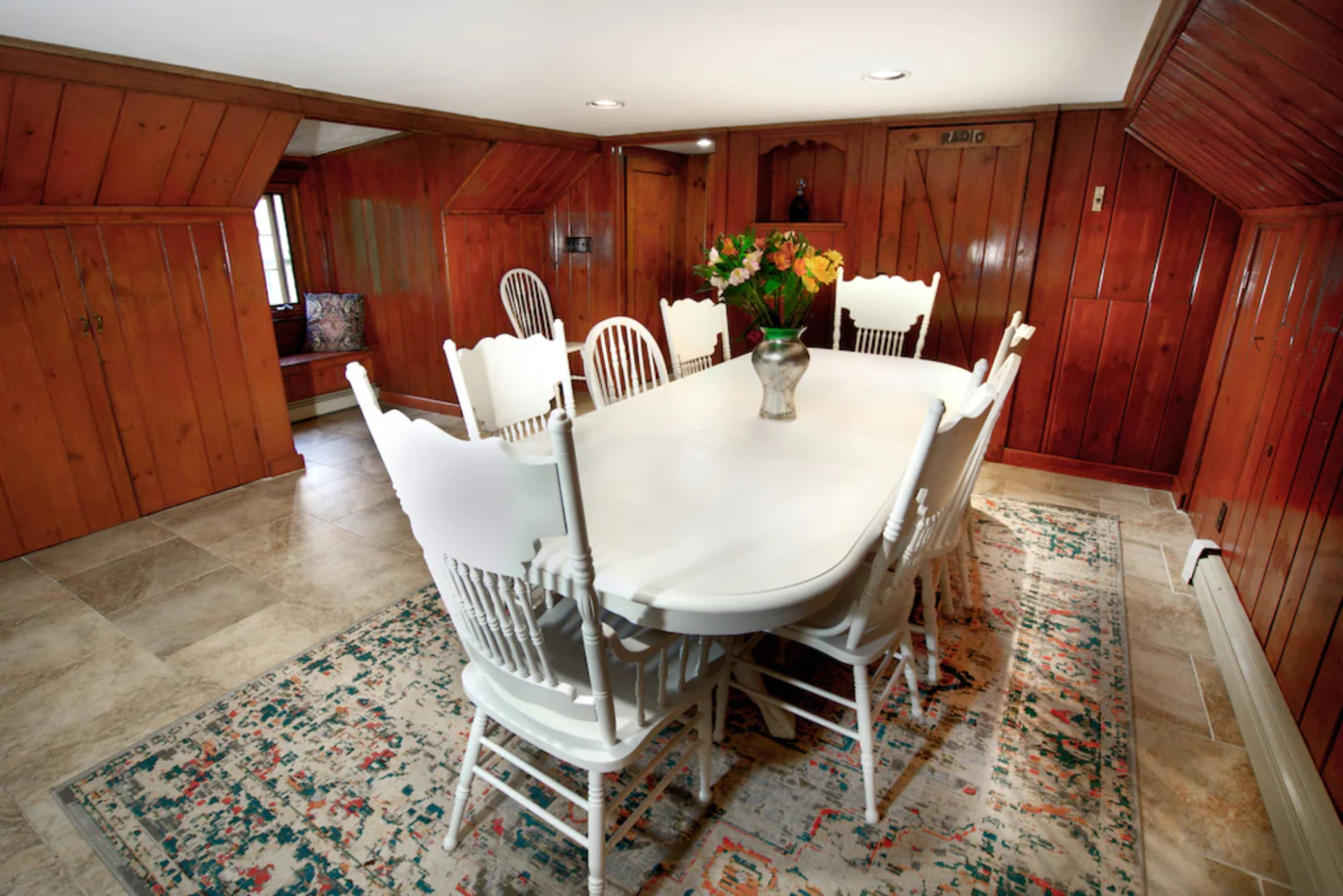 A dining room with a table and chairs and a rug