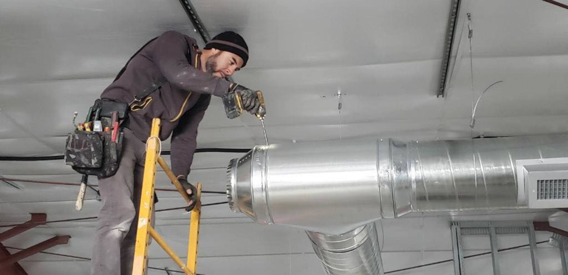 Technician installing HVAC ductwork