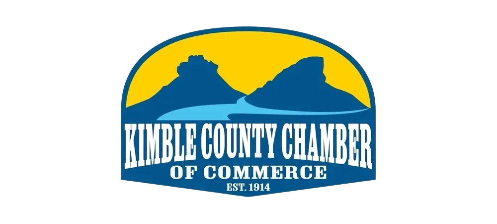 Kimble County Chamber of Commerce logo with blue mountains, river, and yellow sky. Text: Kimble County Chamber of Commerce, Est. 1904.