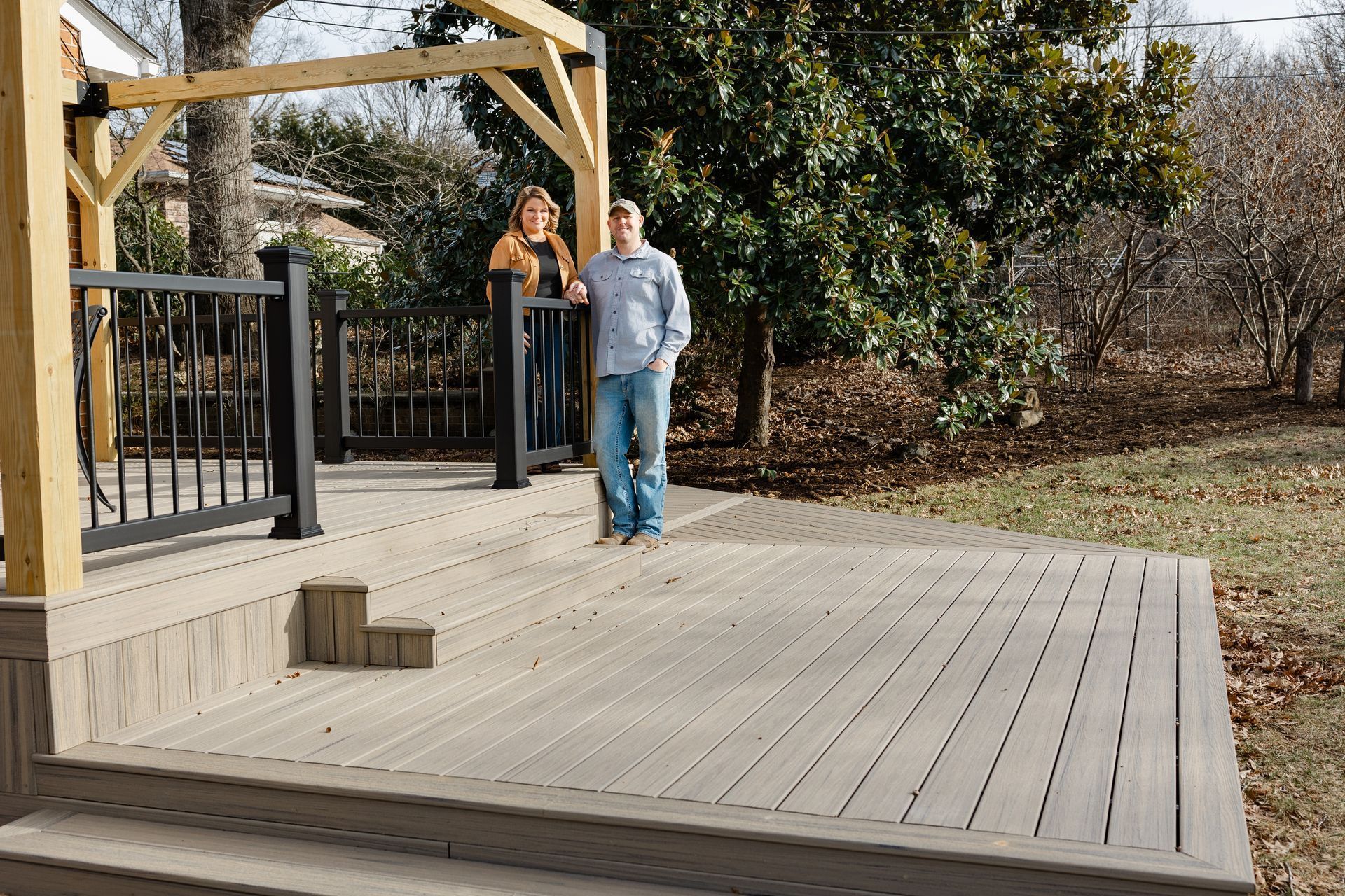 A narrow stone walkway flanked by concrete planter boxes and hedge rows with gravel strips on both sides.