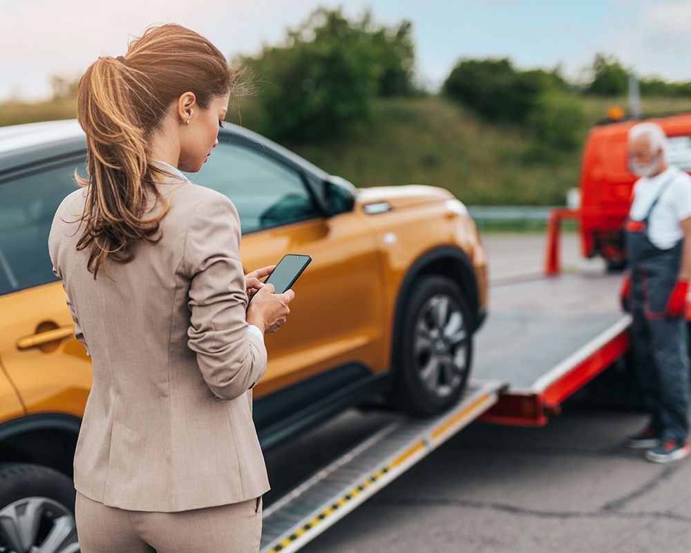 Woman is Standing Next to a Tow Truck