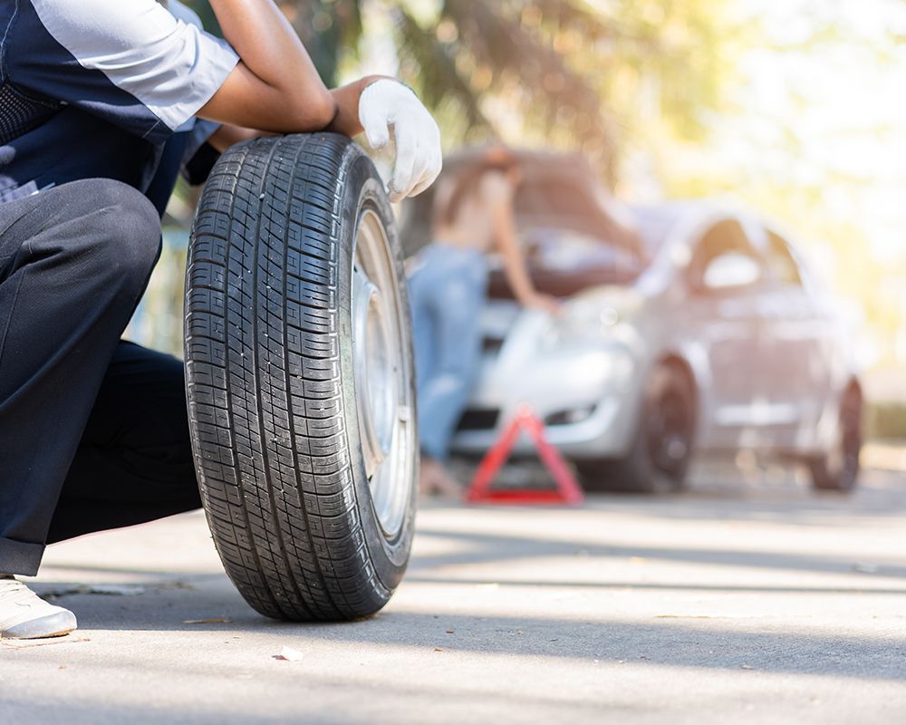 Man is Changing a Tire on the Side of the Road